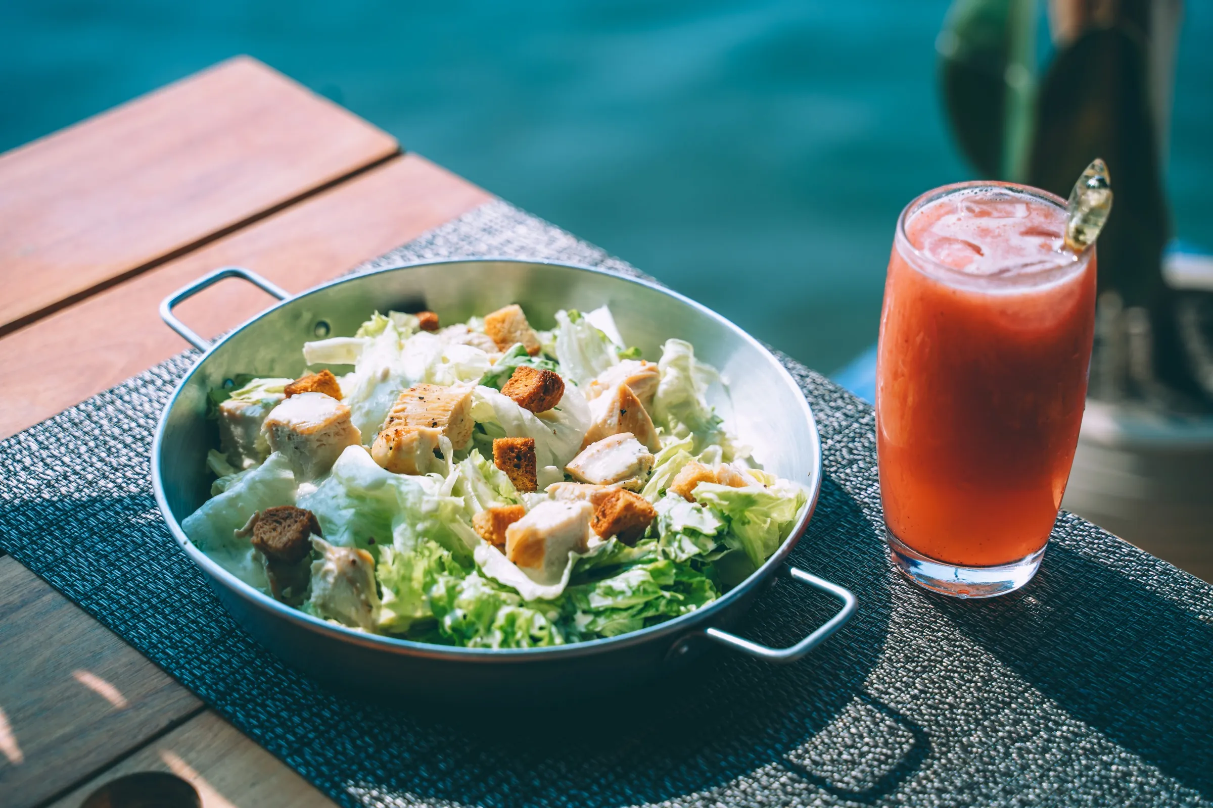 Caesar de frango com suco de melancia à beira do lago