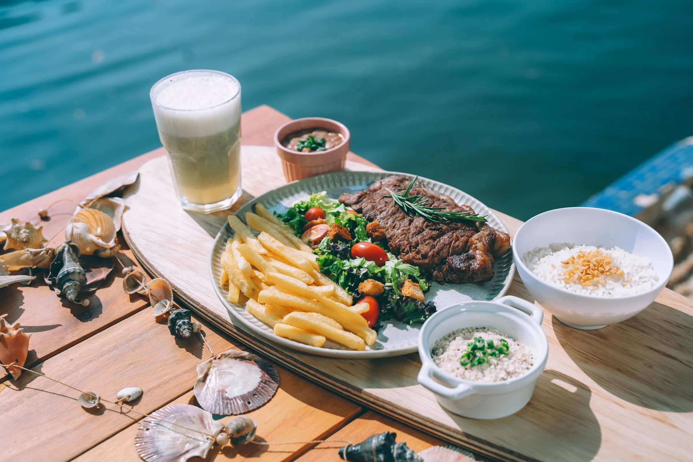 Bife com fritas e limonada suíça com o lago turquesa ao fundo