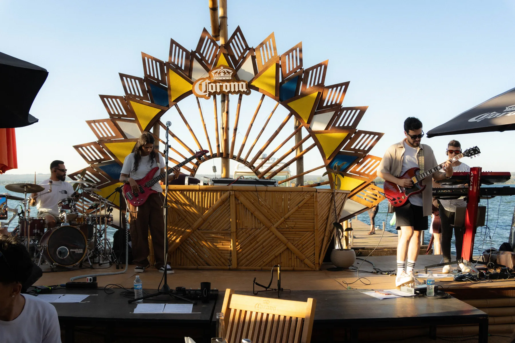 Banda tocando no palco de bambu do Lake Deck, de frente para o Lago Paranoá