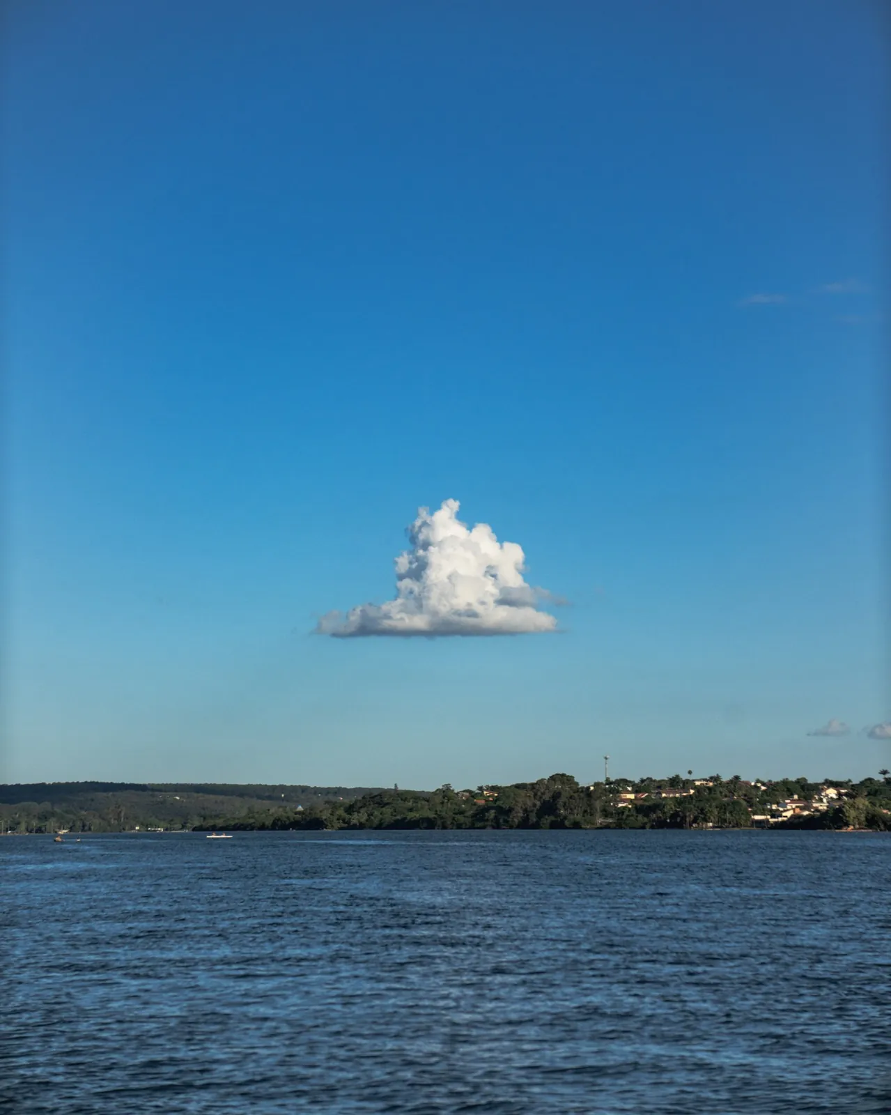 Nuvem solitária sobre o Lago Paranoá calmo